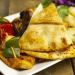 Chicken and pita bread on wooden table