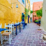 Street cafe in scenic picturesque streets of Chania venetian town with coloful old houses. Chania greek village in the morning. Chanica, Crete island, Greece