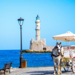Kutsche mit Pferd und im Hintergrund der Leuchtturm – ein Stück traditioneller Chania-Romantik